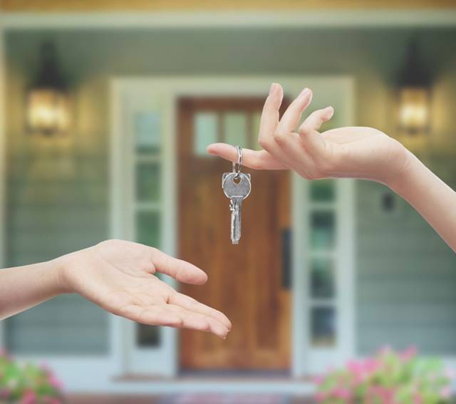 person handing key to new homeowner